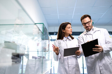 Technologists evaluating product quality in factory test room. Experts testing electronics parts for automobile industry.