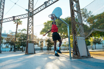 Young basketball player training at the court