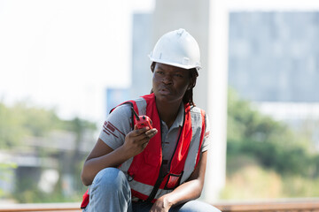 African American female engineer working and performing railway maintenance, wearing safety uniform and helmet