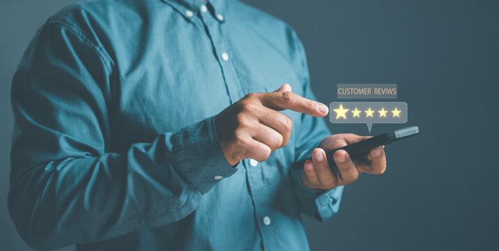 Customer Satisfaction concept, close up hand Man using smartphone with popup five star icon for feedback review satisfaction service, Customer service experience and business satisfaction survey.