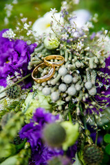 Gold wedding rings on the background of a wedding bouquet