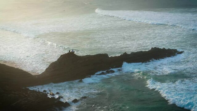 Atardecer sobre roca de Sopelana atravesada por las olas