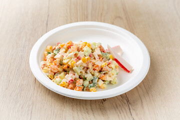 Salad with crab meat and corn. On a light wooden background.