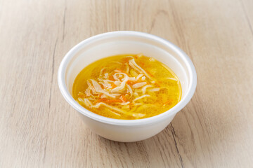 Chicken noodle soup. On a light wooden background.