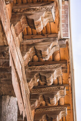 Fototapeta na wymiar Beautifully shaped wooden beams and roofing in an ancient mosque in the ancient city of Bukhara in Uzbekistan, wooden elements of the building