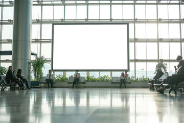 Blank signboard at the airport, in the departure lounge, people are sitting, walking, waiting for their plane - obrazy, fototapety, plakaty