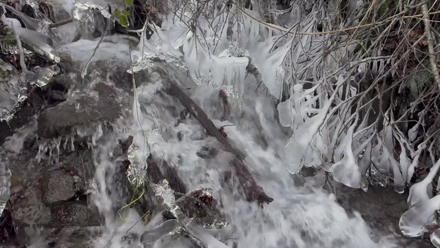 winter, Carpathian frost, the Guk mountain waterfall under the peaks of Khomyak and Synyak carries fast, clean water into the Zhenets River, ice icicles on the rocks