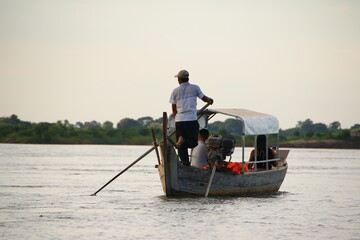 Boat Driver and Tourists on the lookout for Dolphins (Mekong River, Kratié, Cambodia) 
