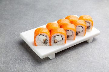Japanese Sushi roll Philadelphia with eel on a white stand, gray background