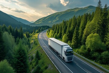 A white truck travels a highway winding through vibrant green mountains under a sunset