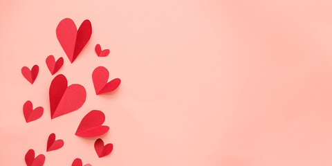 Red paper hearts isolated on pink background