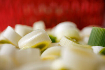 Vue macro de rondelles de poireaux disposées devant une passoire à salade