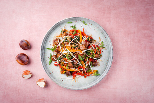 Traditionelle asiatischer Wok Spinat mit Maronen, Paprikastreifen und Sojasprossen serviert als Draufsicht in einer Nordic Design Teller mit Textfreiraum