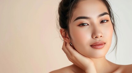Experience perfection with a close-up of a young Asian woman delicately massaging her flawless face. Explore the essence of beauty in our face cream commercial.