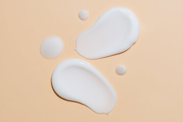 Skin care cream, face serum, lotion swatch smear on beige background. White light creamy cosmetic beauty product smudge swipe closeup