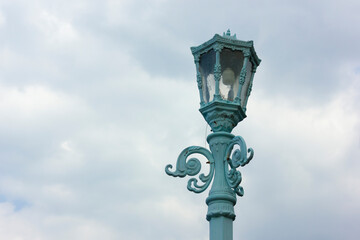 Fototapeta na wymiar Antique blue lamp isolated on sky background, cloudy