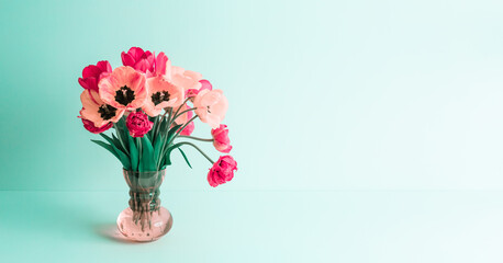 Big flowers bouquet of pink tulips in vintage glass vase on green background. Copy space. Business...