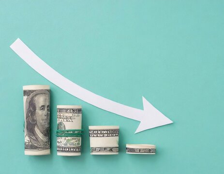 Decreasing stacks of US dollar bills with a downward arrow