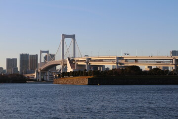 Rainbow Bridge in dusk viewed from Odaiba Seaside Park in Tokyo, Japan