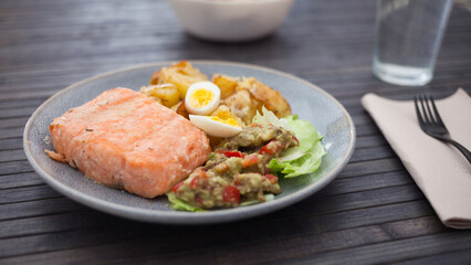 baked salmon fillet with fried potato wedges, homemade guacamole and quail eggs halves
