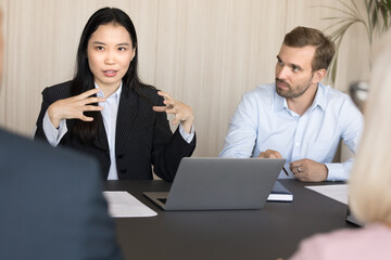 Pretty young business manager woman presenting project marketing strategy to investors on meeting,...