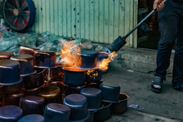 N4w copper pots and kettles are thermally tempered using propane blowtorch on streets of Turkey.