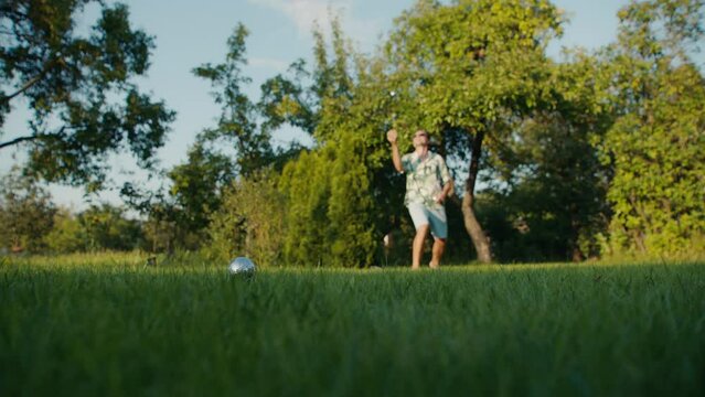 A man plays boules in the park