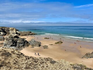 Sandy ocean beach, blue sea horizon, rocky ocean coast, view from the mountains