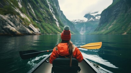 View from the back of a girl in a canoe floating on the water among the fjords  - obrazy, fototapety, plakaty