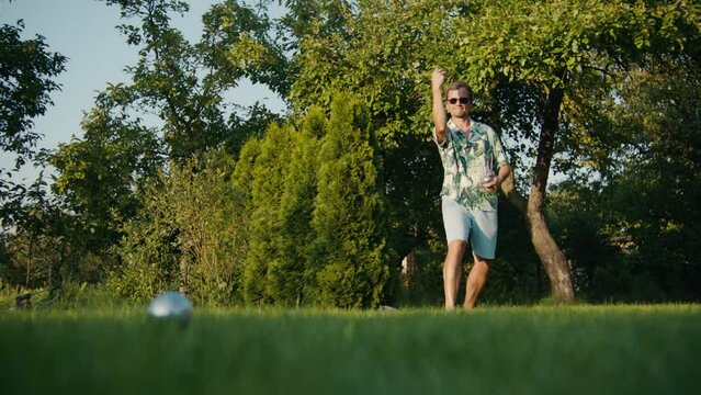 A man plays boules in the park