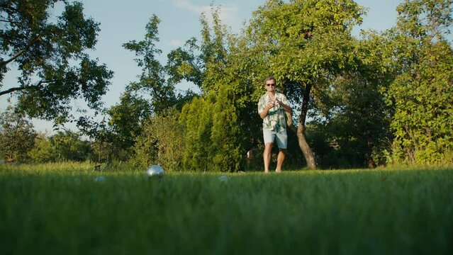 A man plays boules in the park