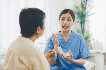 Woman dentist in dental office talking with Senior female patient and preparing for treatment. A...