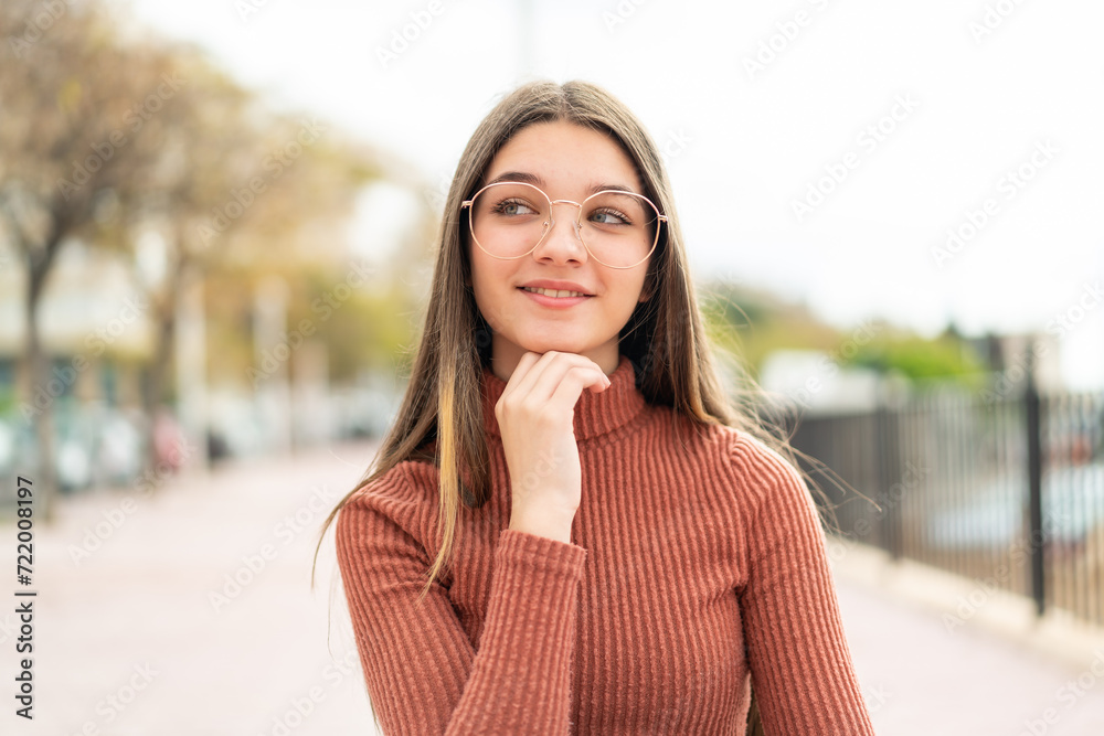 Poster Teenager girl at outdoors With glasses and thinking while looking up