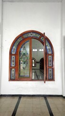 The opened window in mosque with moslem ornament on its glass 