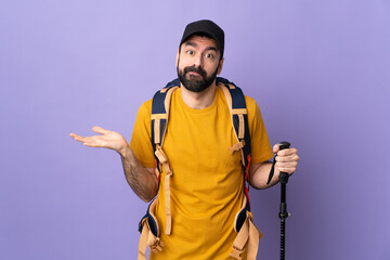 Caucasian handsome man with backpack and trekking poles over isolated background having doubts while raising hands