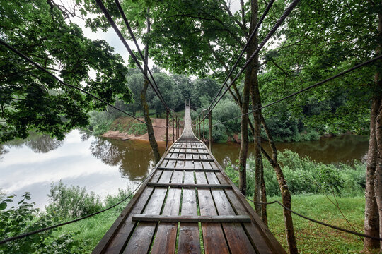 Hanging monkey bridge over the Minija river in Lithuania. Wide angle photography.