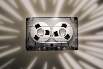 Light rays projection background, photographed with the help of a gobo mask with a retro audio cassette in 1990s disco music style