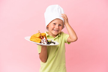 Little Russian boy holding waffles over isolated background