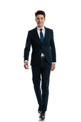 handsome young man in navy blue suit smiling and walking