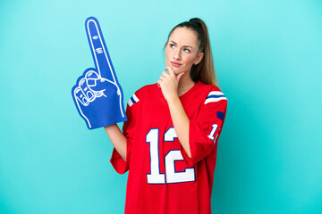 Young caucasian sport woman isolated on blue background having doubts