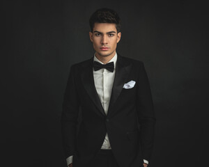 portrait of elegant young man in black tuxedo