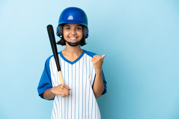 Baseball mixed race player woman with helmet and bat isolated on blue background pointing to the side to present a product