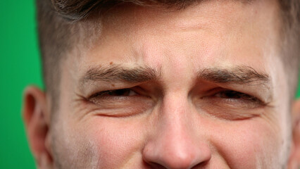 Obraz premium Man's eyes, close-up, on a green background