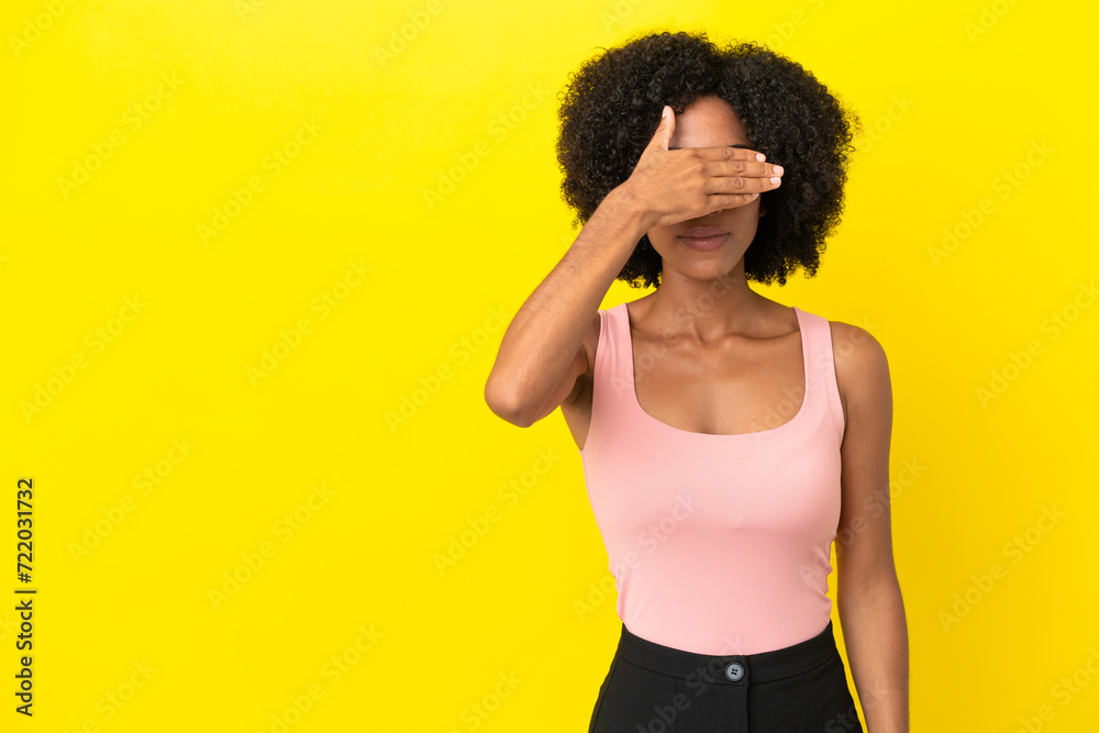 Wall mural Young African American woman isolated on yellow background covering eyes by hands. Do not want to see something