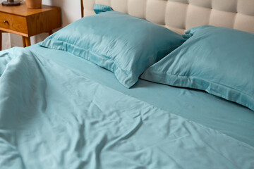 Close up of Messy bed blue cotton crumpled fabric natural textile