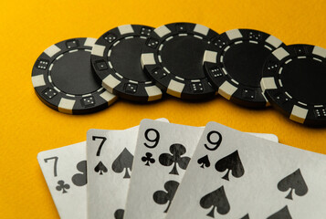 Popular poker game with winning two pairs. Chips and cards on a yellow table
