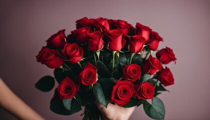 cropped hand holding a bouquet of red roses, isolated red background
