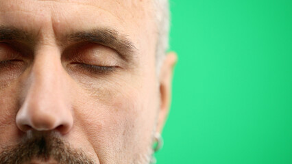Fototapeta premium Man's eyes, close-up, on a green background