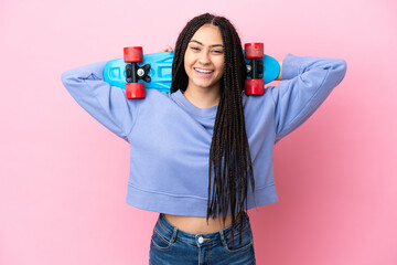 Teenager girl with braids over isolated pink background with a skate with happy expression