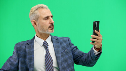 Man, close-up, on a green background, talking on the phone